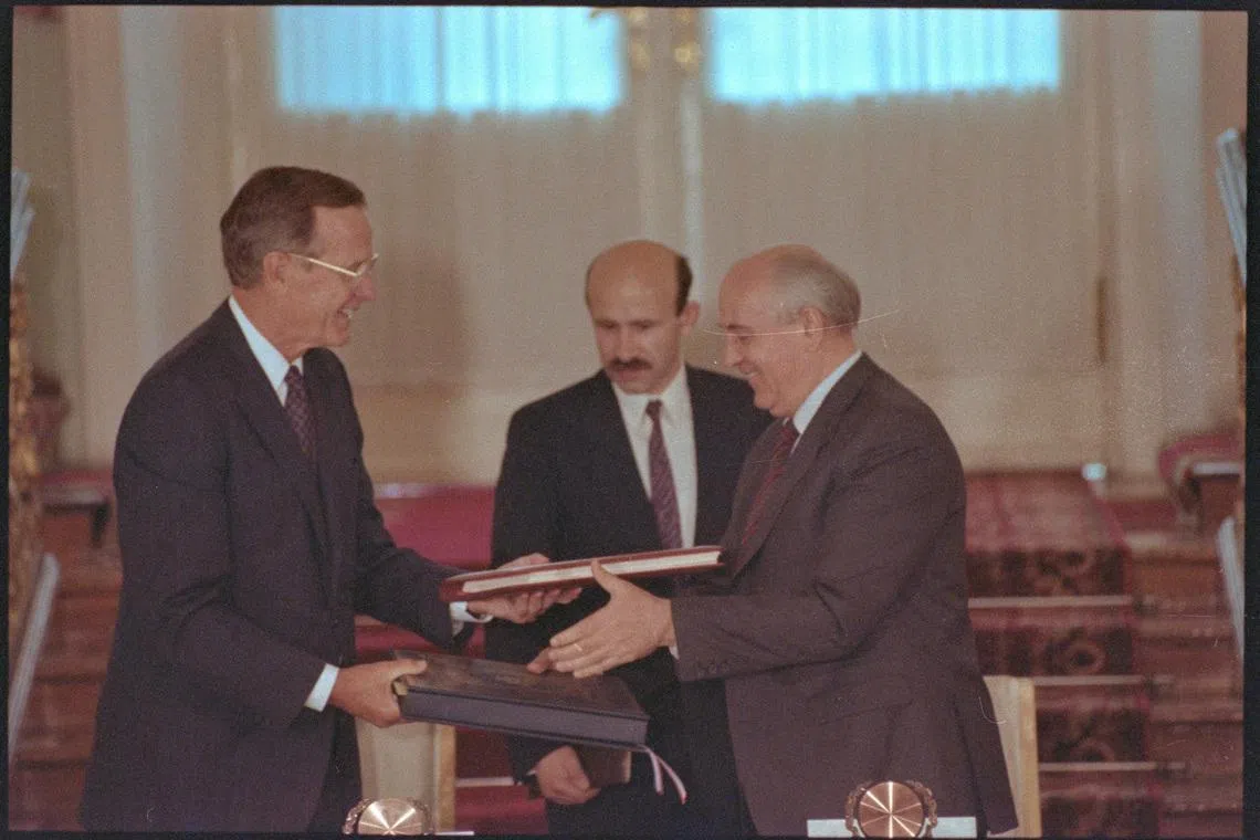 FILE PHOTO: US President George Bush and Soviet President Mikhail Gorbachev exchange documents after signing the START arms reduction treaty.  July 31, 1991 REUTERS/Larry Rubenstein   DISCLAIMER: The image is presented in its original, uncropped, and untoned state. Due to the age and historical nature of the image, we recommend verifying all associated metadata, which was transferred from the index stored by the Bettmann Archives, and may be truncated./File Photo