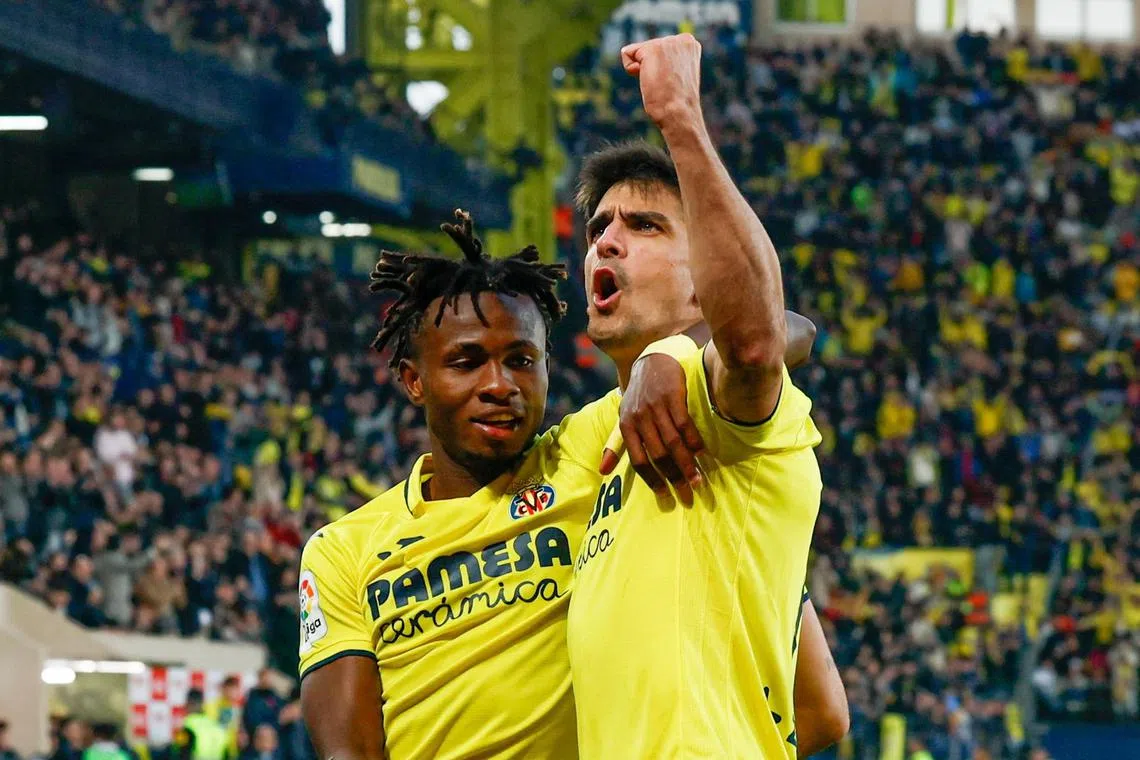 Villarreal's striker Gerard Moreno (right) celebrates with teammate Samu Chukwueze after scoring his team's second goal.