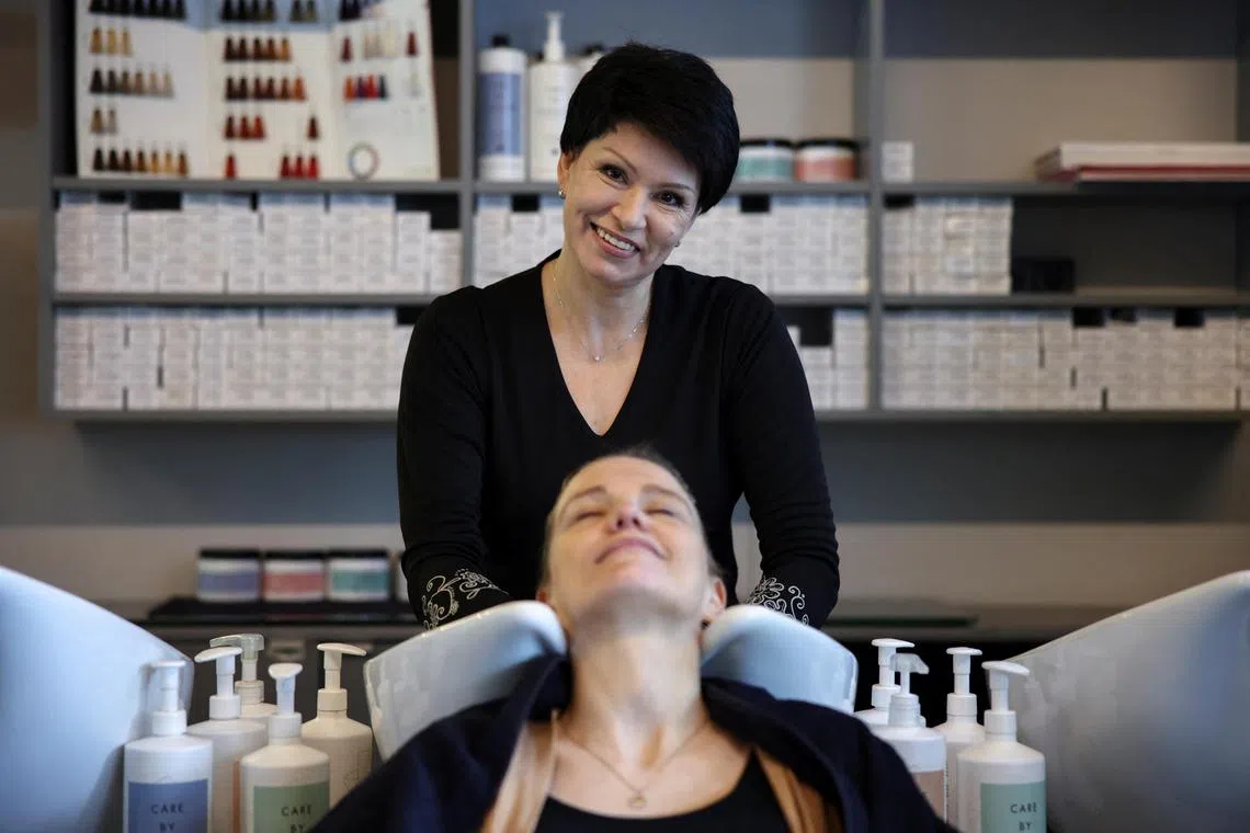 Valentyna Vysotska, a Ukrainian refugee, works at a hairdressing salon in Charlottenburg, Berlin, Germany, April 22, 2024. REUTERS/Liesa Johannssen