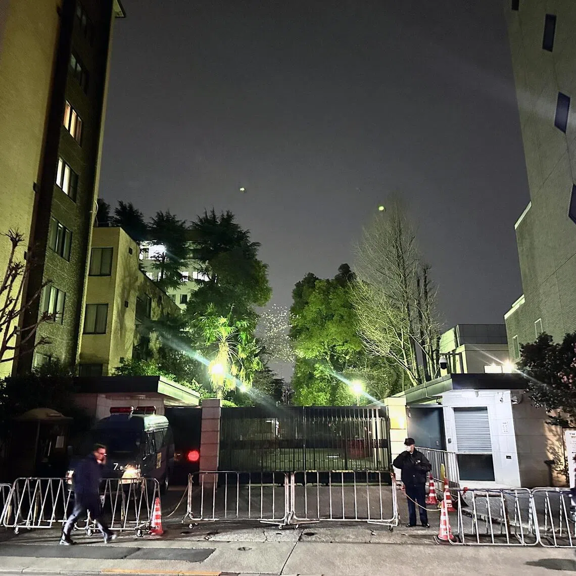 Police officers stand guard in front of the Chinese Embassy in Tokyo, Japan.