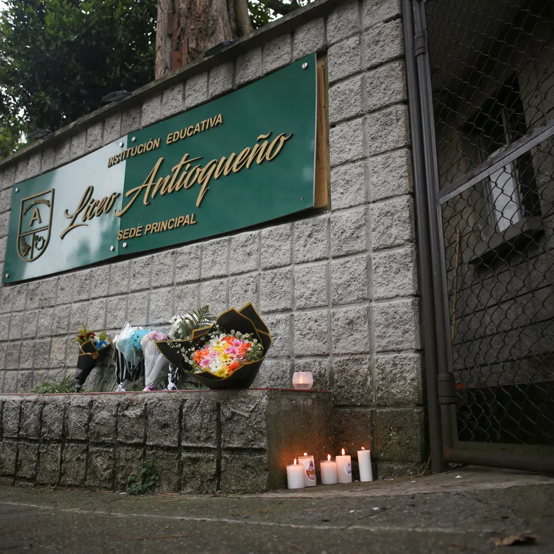 Candles are placed at a makeshift memorial at the Liceo Antioqueno school, where victims of a recent bus accident had studied, in Bello, Colombia, December 14, 2025. REUTERS/Juan David Quintero