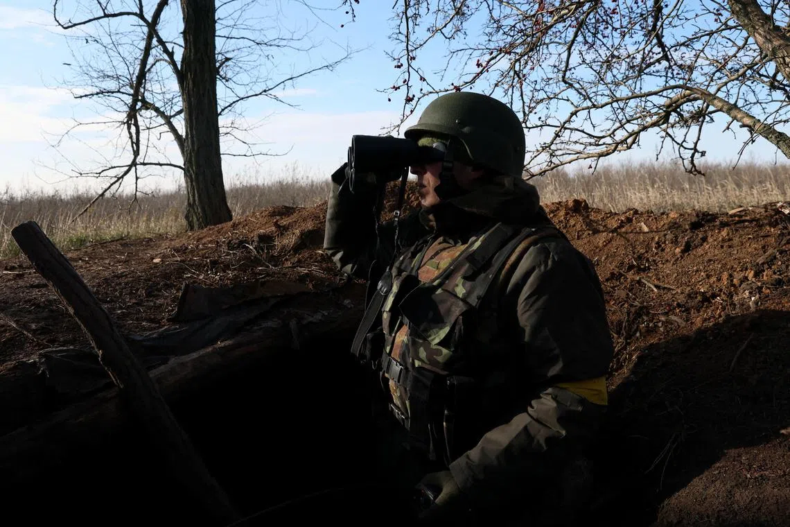 A Ukrainian soldier scans the horizon for Russian military from his position in the trenches near the frontline in the southern Donbas region in Ukraine, November 29, 2022.