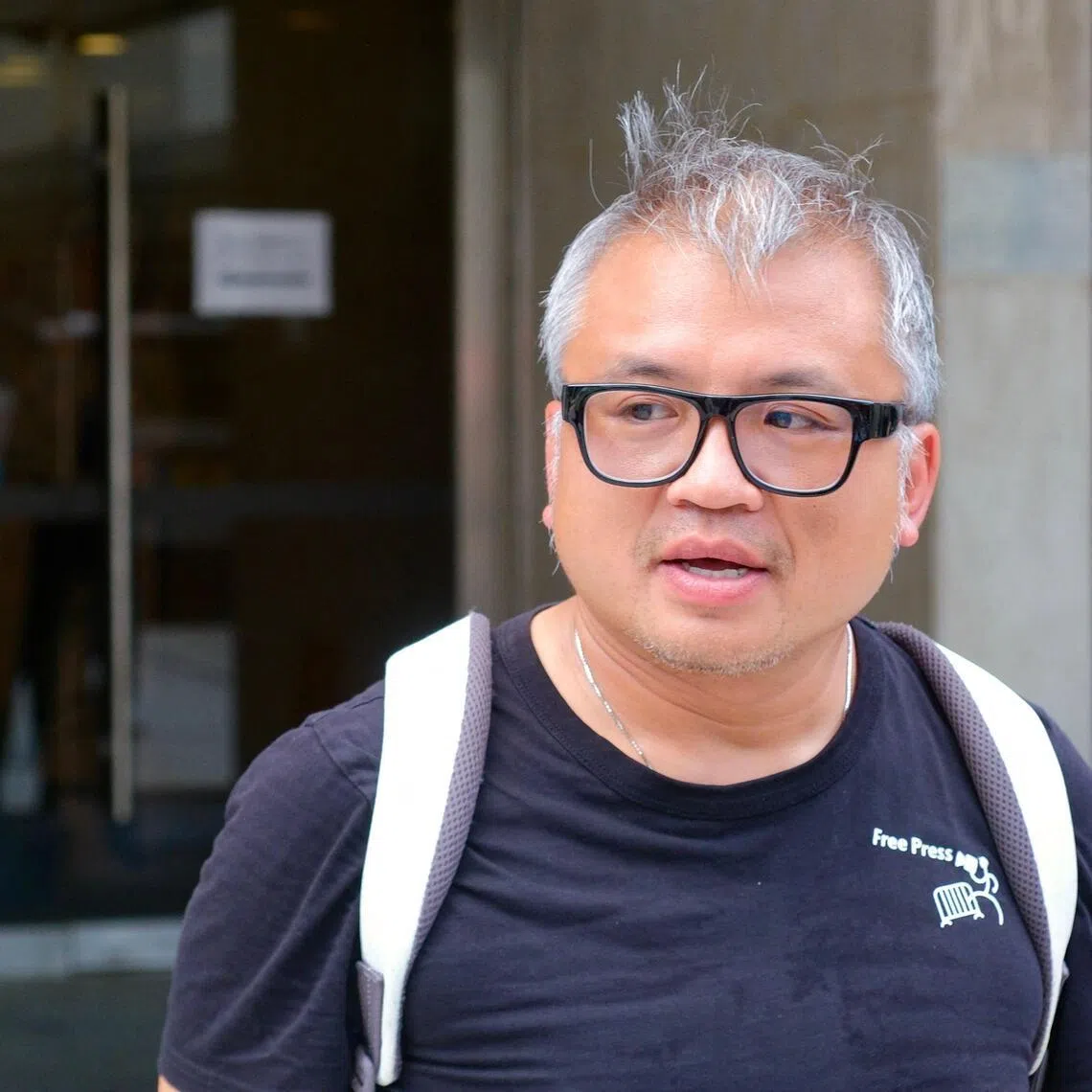 Journalist Ronson Chan wears a black shirt that reads “Free Press” speaks to reporters at Hong Kong’s High Court.
