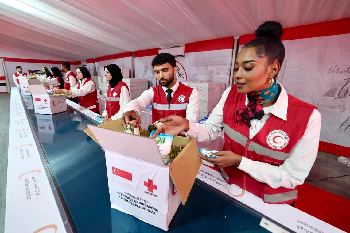Egyptian Red Crescent volunteers in Cairo packing aid from the Singapore Red Cross to deliver to Palestinians in September. 