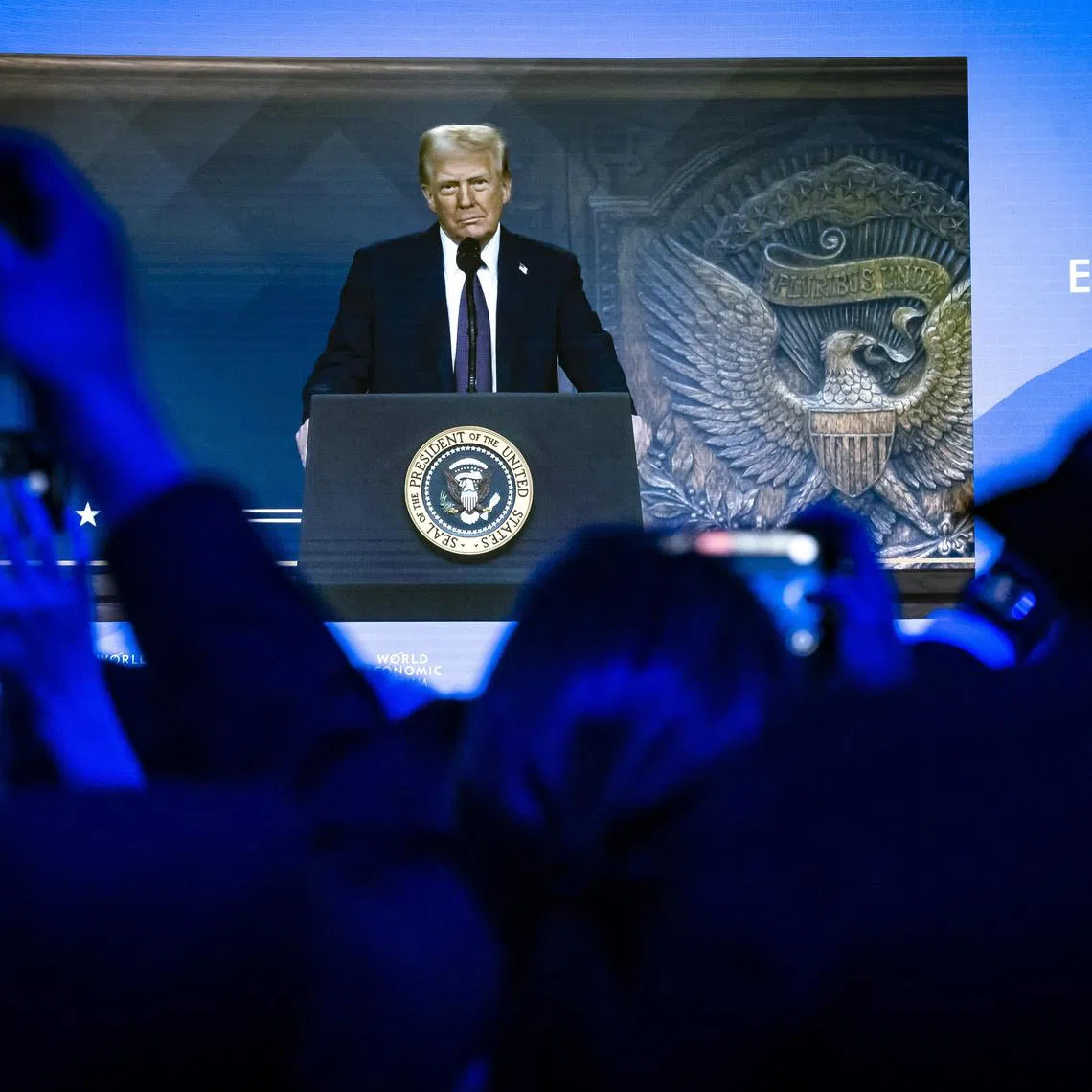 epa11847766 US President Donald J. Trump is shown on a screen as he addresses via remote connection a plenary session in the Congress Hall during the 55th annual meeting of the World Economic Forum (WEF) in Davos, Switzerland, 23 January 2025. The World Economic Forum annual meeting brings together entrepreneurs, scientists, corporate and political leaders in Davos and takes place from January 20 to 24.  EPA-EFE/MICHAEL BUHOLZER