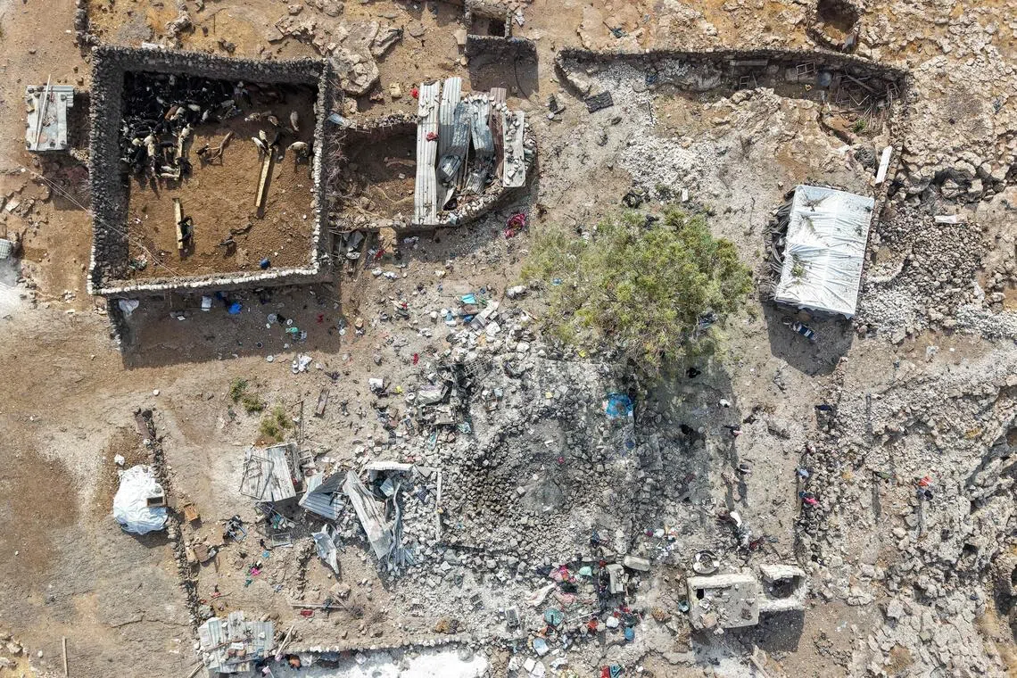 People inspecting the damage at a site targeted by Jordanian air strikes in the north-eastern countryside of Daraa on Oct 27.