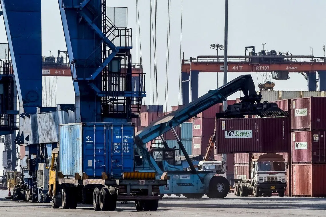 A crane loads shipping containers on a truck at the Deendayal Port Authority (DPA) in Kandla in India's Gujarat state on April 5, 2025. US President Donald Trump ignited a potentially ruinous global trade war on April 2 as he slapped 10 percent tariffs on imports from around the world and harsh extra levies on key trading partners. (Photo by Sam PANTHAKY / AFP)