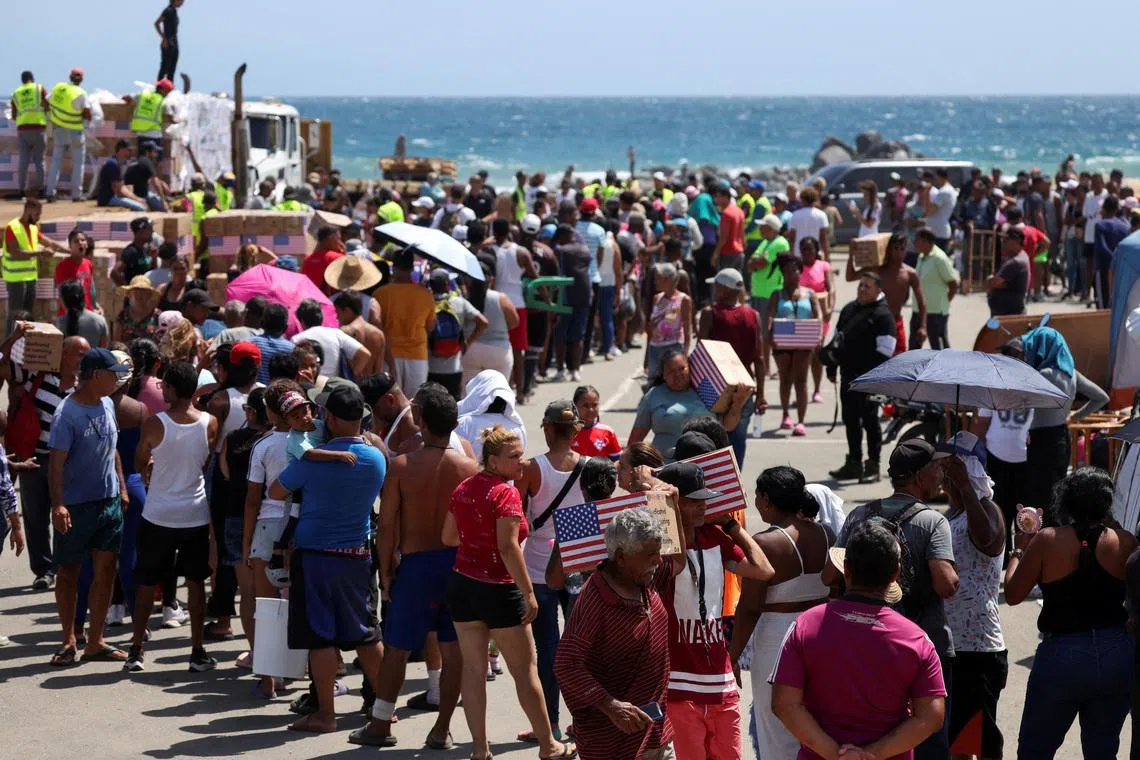 People affected by the disaster queue to receive humanitarian aid distributed by personnel from the US-based non-profit organization Global Empowerment Mission (GEM), in the aftermath of the June 24 earthquakes, in Catia la Mar, La Guaira state, Venezuela July 8, 2026. REUTERS/Leonardo Fernandez Viloria