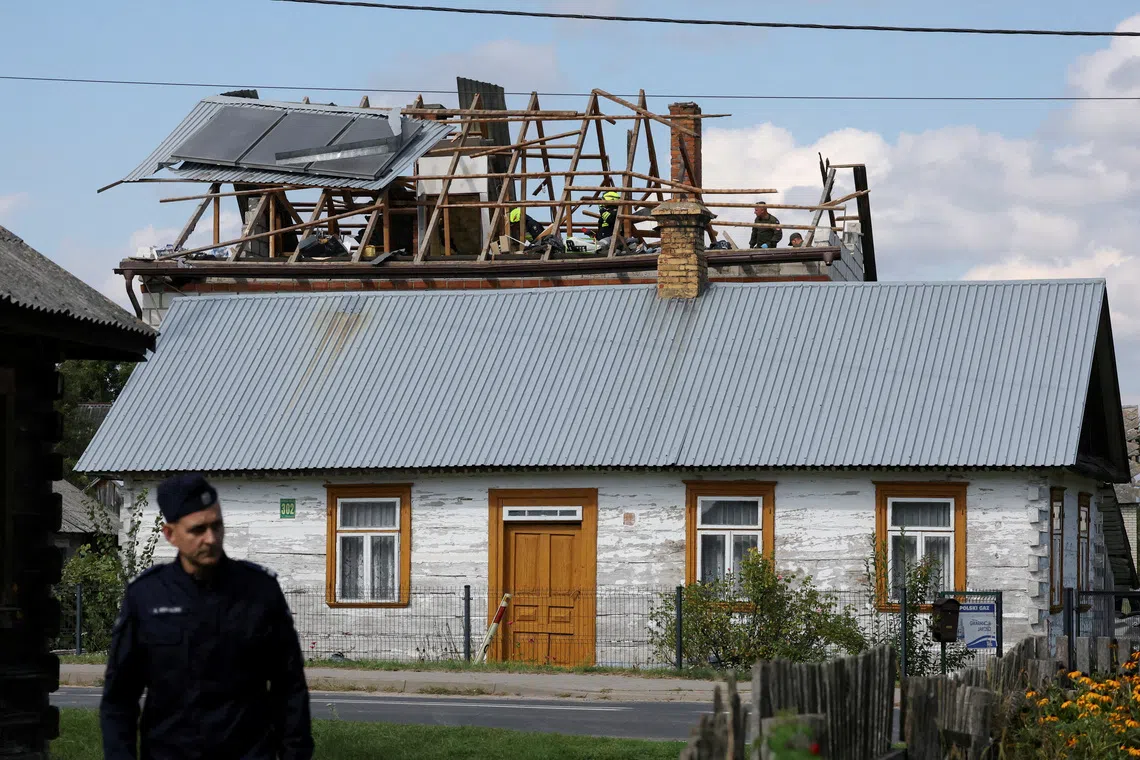 Firefighters working on the destroyed roof of a house after Russian drones violated Polish airspace during an attack on Ukraine in September.