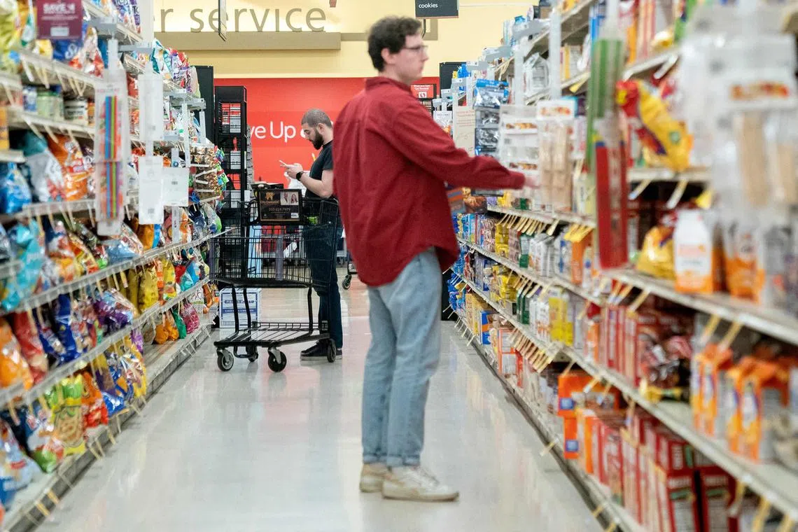 (FILES) Shoppers look at items displayed at a grocery store in Washington, DC, on February 15, 2023. A key indicator of US inflation cooled in June to the lowest annual rate in over two years, although this remains above the central bank's target, according to government data released on July 28, 2023. The Federal Reserve's preferred gauge of inflation, the personal consumption expenditures (PCE) price index, rose 3.0 percent last month from June 2022, down from a 3.8 percent jump in May, said the Commerce Department. (Photo by Stefani Reynolds / AFP)