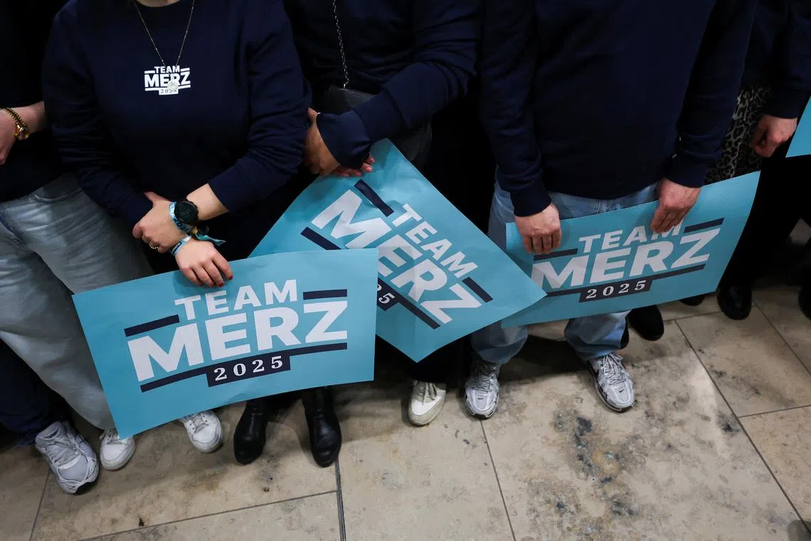 People hold signs in support of German conservative candidate for chancellor and Christian Democratic Union (CDU) party leader Friedrich Merz, during the 2025 general election, at the CDU party headquarters in Berlin, Germany, February 23, 2025. REUTERS/Kai Pfaffenbach