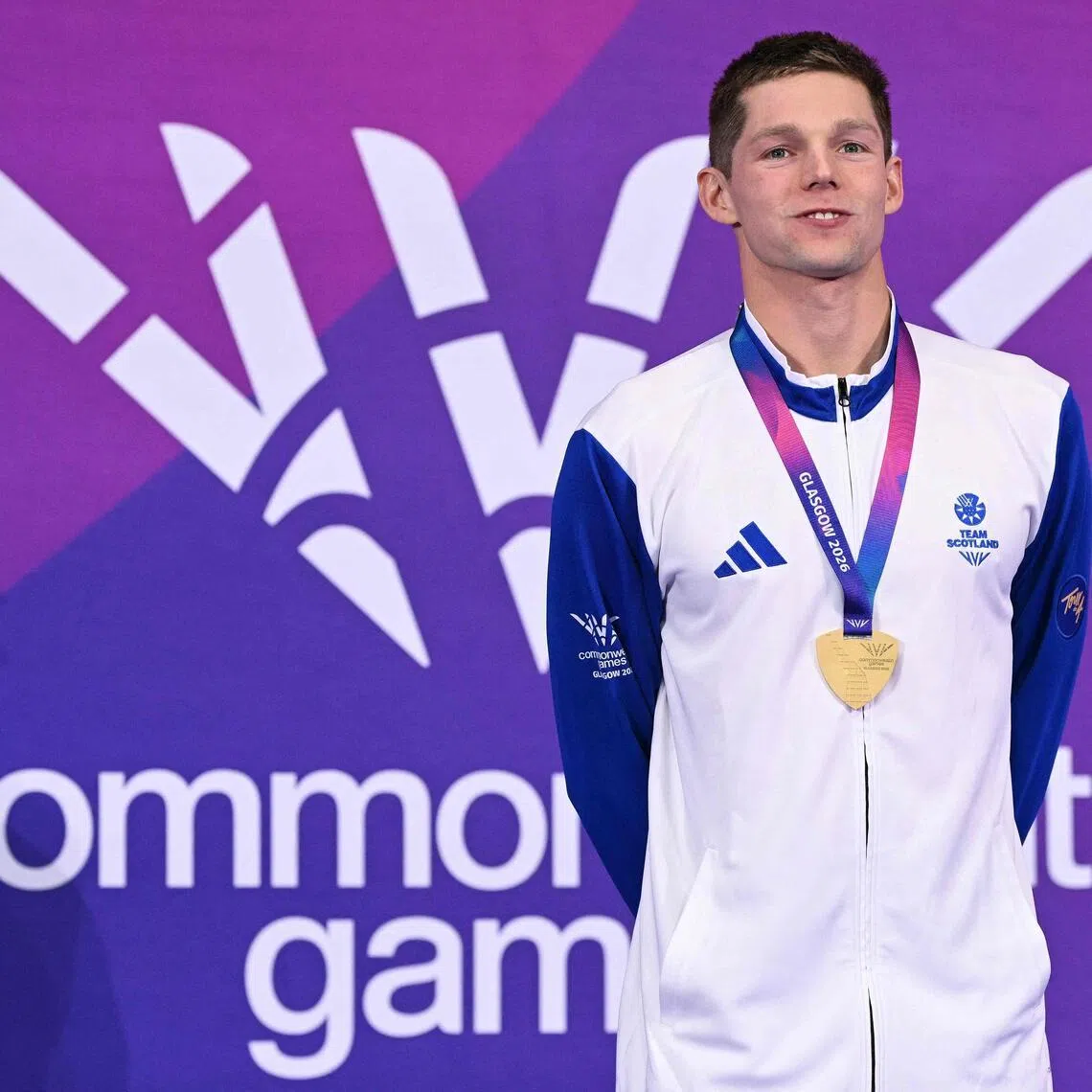 Scotland's Duncan Scott celebrates with his gold medal during the Men's 200m Individual Medley Medal Ceremony at the swimming event at the Tollcross International Swimming Centre in Glasgow, on day one of the Commonwealth Games in Glasgow, Scotland, on July 24, 2026. (Photo by Oli SCARFF / AFP)