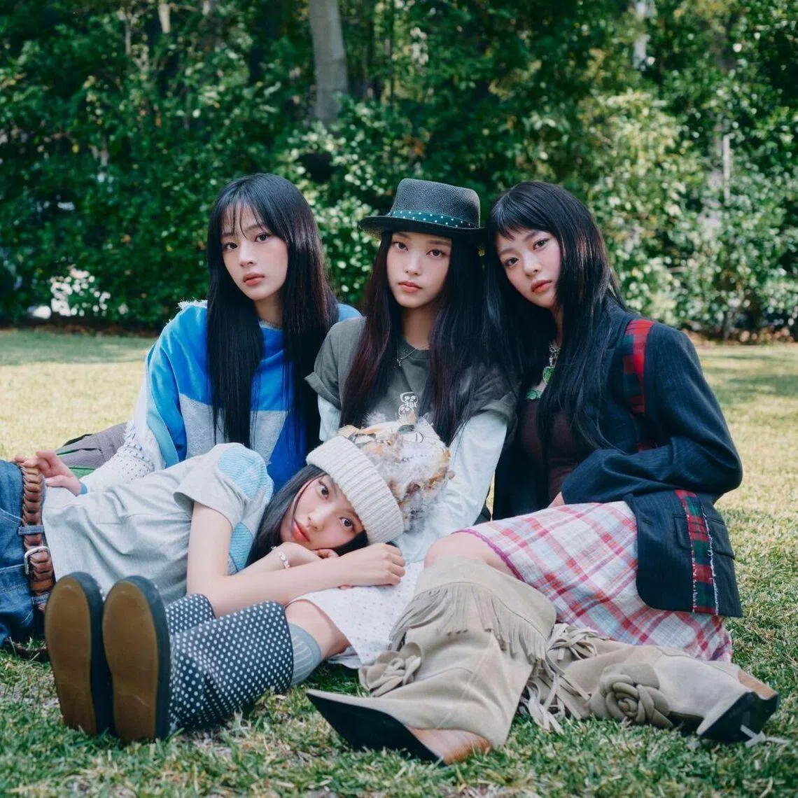 NewJeans members (seated, from left) Minji, Haerin, Hanni and Hyein (lying down) in the group’s latest promotional campaign.