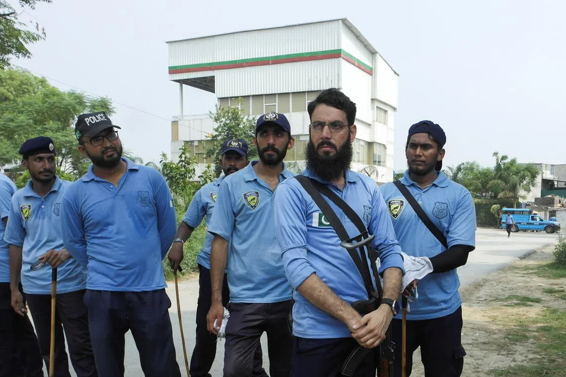 Police officers stand with the Pakistan Tehreek-e-Insaf (PTI) party secretariat building in the background during a raid in Islamabad, Pakistan July 22, 2024. REUTERS/Salahuddin