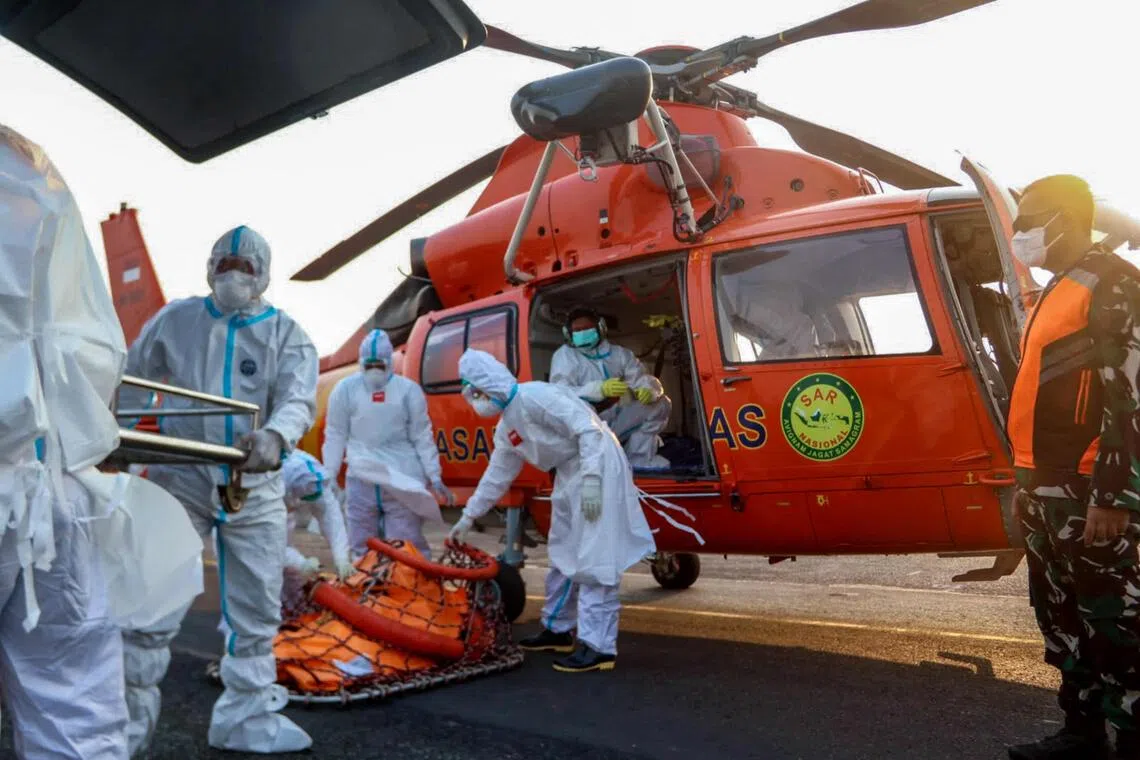 A handout photo on Sept 20, 2026 by Basarnas showing rescue officials carrying body bags with the remains of victims recovered from the Virgo Transport 8 ship accident, upon arrival by helicopter at Syamsudin Noor Airport in Banjarmasin in South Kalimantan.