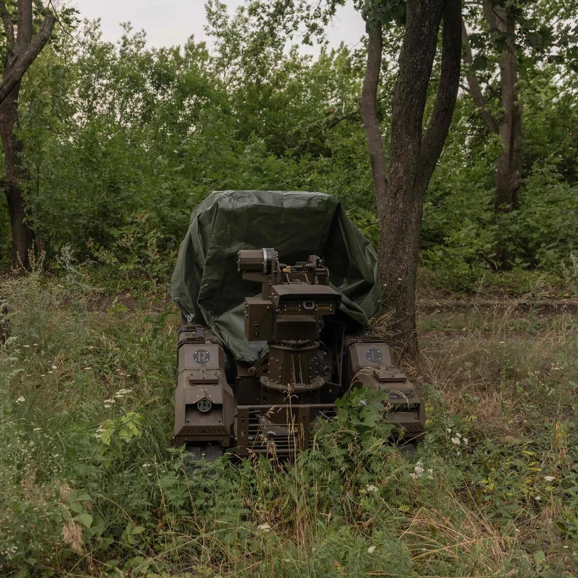 Ukrainian soldiers testing a Droid NW 40 unmanned ground combat vehicle at an undisclosed location in July 2026.