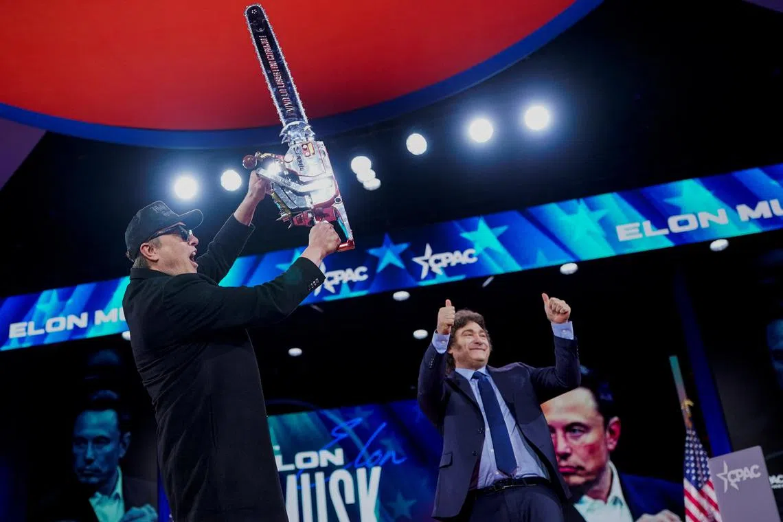 Mr Musk holds up a chainsaw as Argentina's President Javier Milei gives two thumbs up at the CPAC in National Harbour, Maryland.