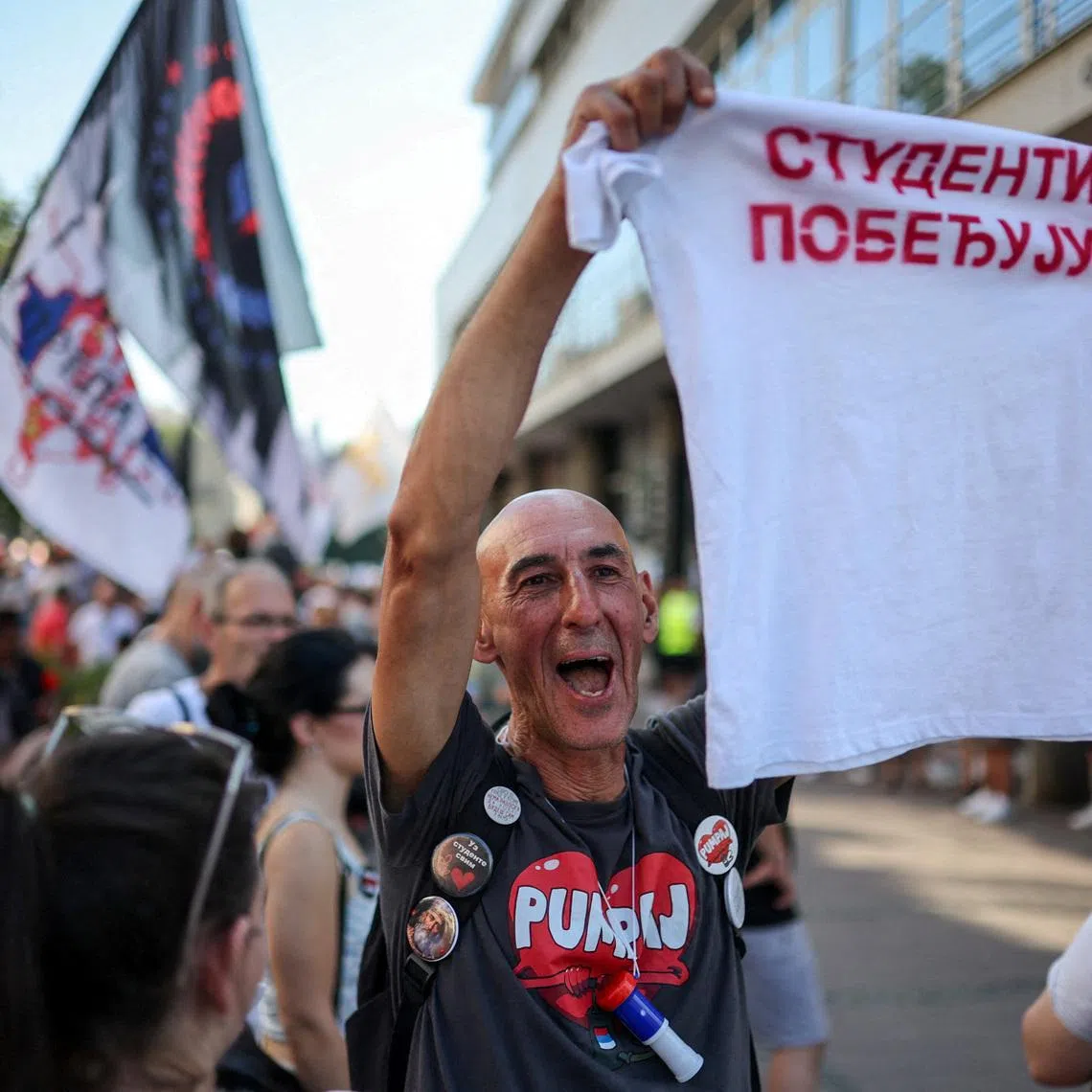 A man holds a t-shirt that reads \"Students are winning\" as people gather for a protest, as part of a nationwide anti-government movement triggered by the deadly collapse of the Novi Sad railway station canopy in November 2024, following Serbian President Aleksandar Vucic's resignation announcement, in Kraljevo, Serbia, June 28, 2026. REUTERS/Djordje Kojadinovic