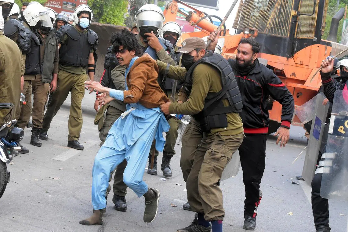 A man is detained amid clashes between the police and Mr Khan’s supporters outside his residence in Lahore, on March 18, 2023.