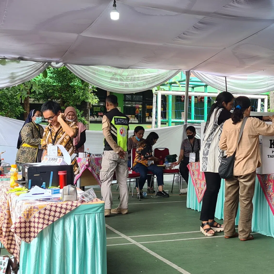 Voters putting ballot cards into a box at a polling station in Jakarta.