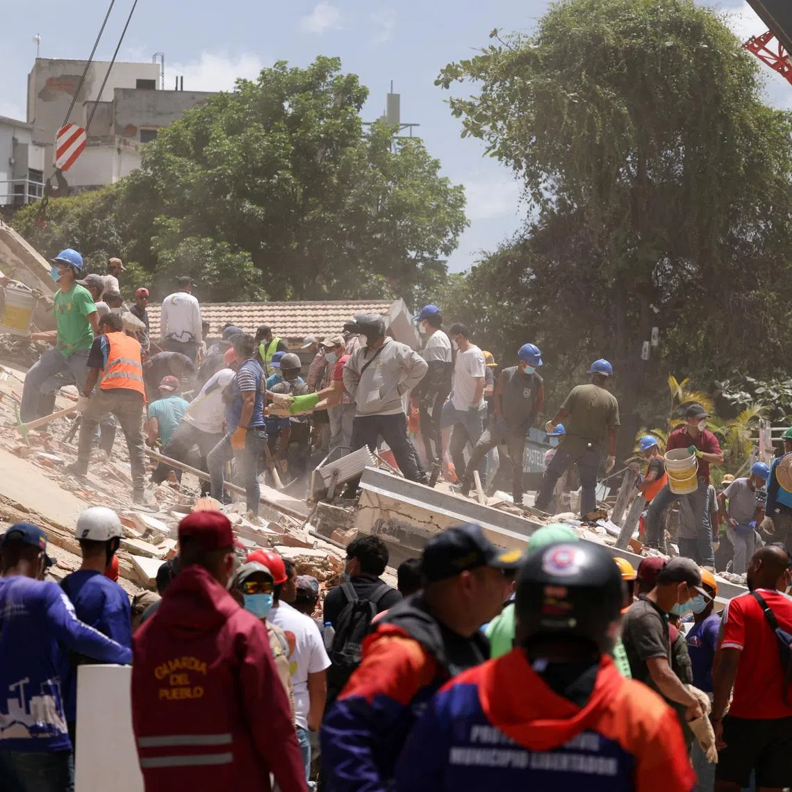 People searching for casualties amid the rubble of a collapsed building, in the aftermath of earthquakes in Caracas, Venezuela, on June 25.