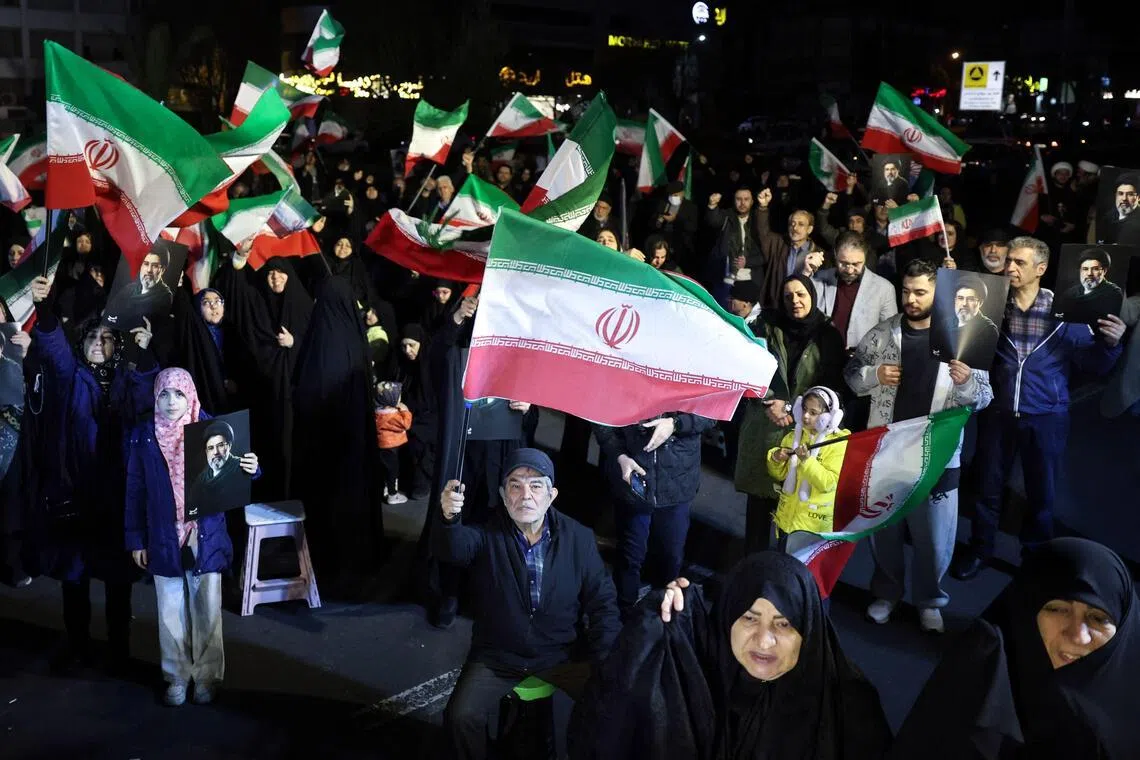 People waving national flags and holding portraits of Iran's supreme leader Mojtaba Khamenei in central Tehran on March 25.