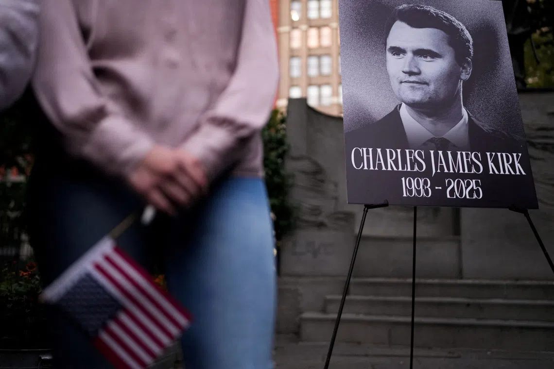 FILE PHOTO: A person holds a U.S. flag as people gather during a vigil for U.S. right-wing activist and commentator Charlie Kirk, who was fatally shot while speaking at an outdoor event at Utah Valley University, at Madison Square Park in New York City, U.S., September 12, 2025.   REUTERS/Adam Gray/ File Photo