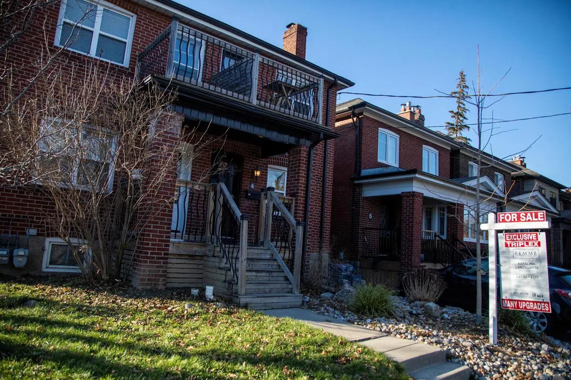 FILE PHOTO: A for sale sign is displayed outside a home in Toronto, Ontario in Toronto, Ontario, Canada December 13, 2021.  REUTERS/Carlos Osorio/File Photo