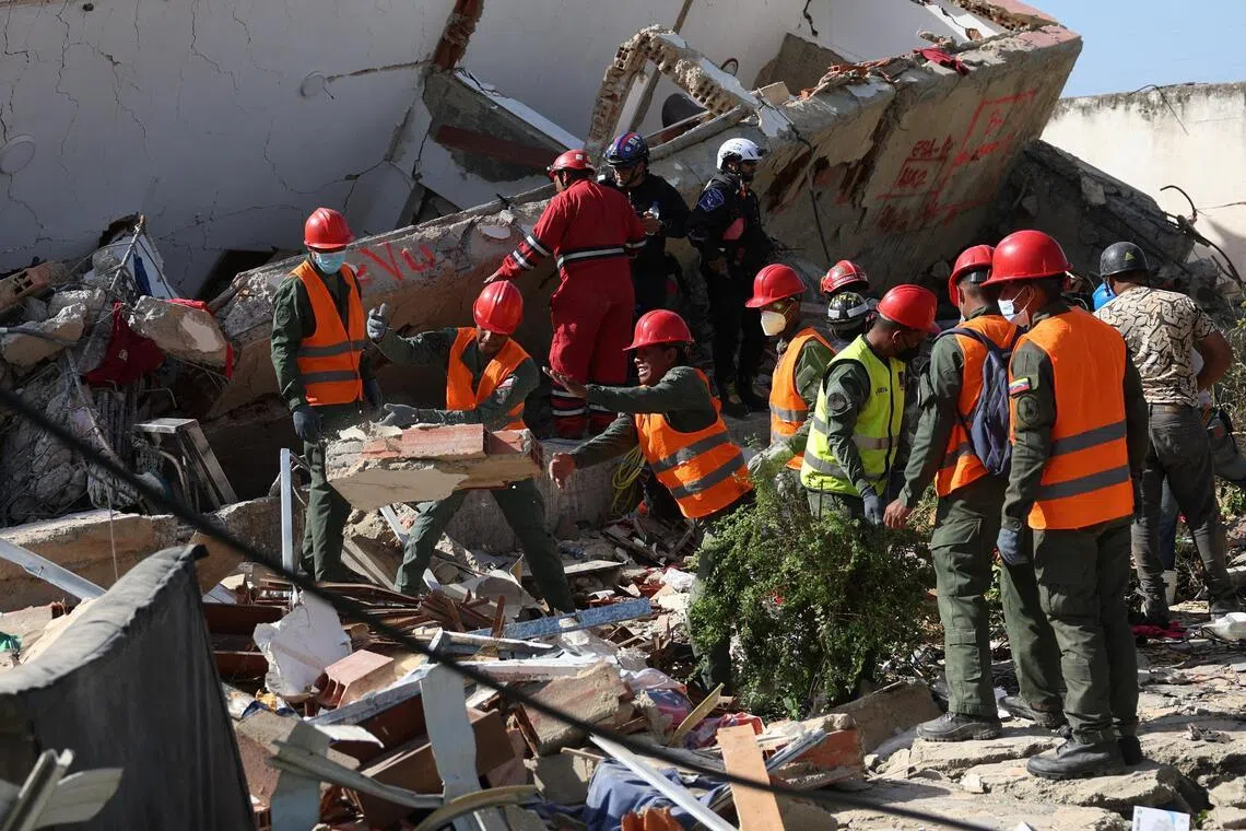 Members of the military remove debris at the site of a collapsed building in the aftermath of the June 24 earthquakes in La Guaira, Venezuela.
