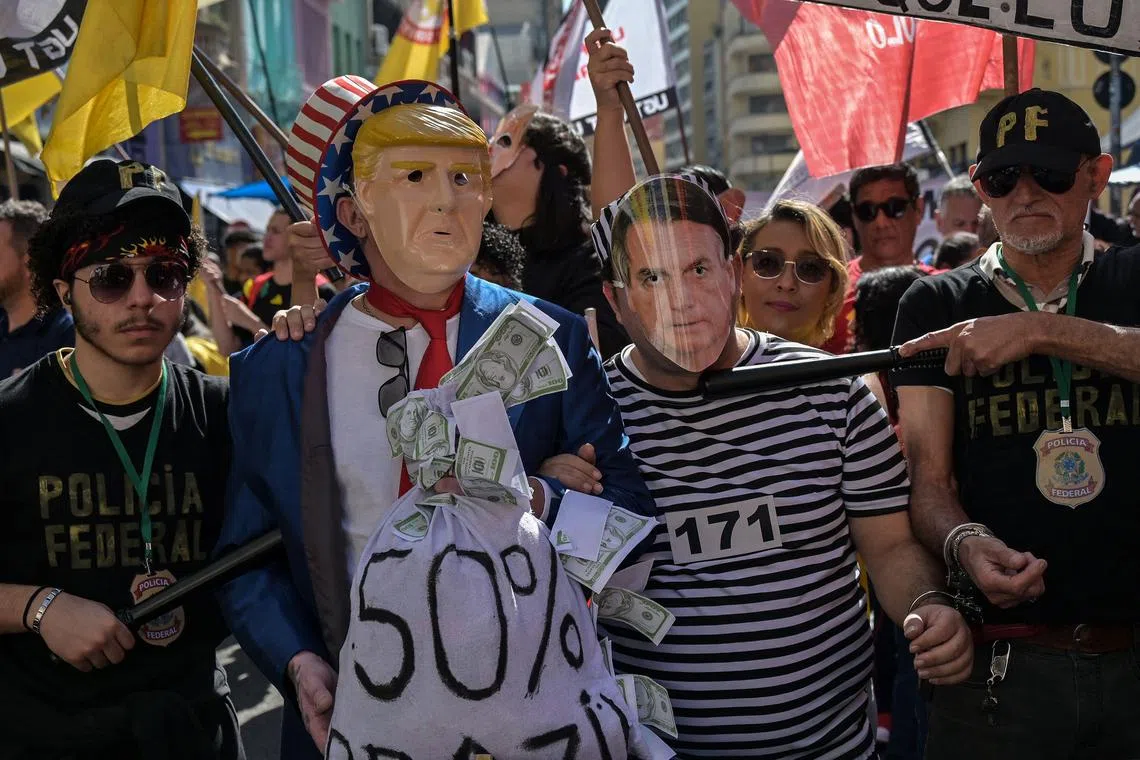 Brazilian protesters wear masks depicting  US President Donald Trump and former Brazilian president Jair Bolsonaro at a rally in Sao Paulo, on July 18.