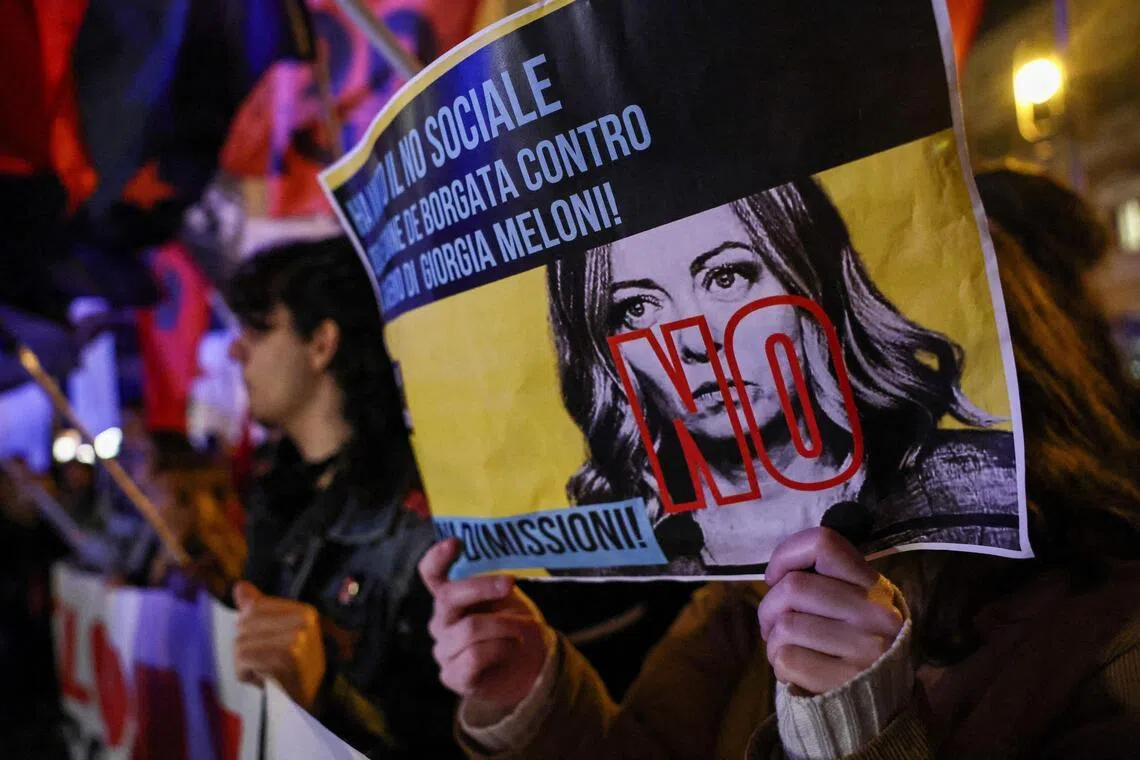 Supporters who said "No" to justice reform in the referendum celebrate their victory in Rome, with one holding a placard featuring Prime Minister Giorgia Meloni.
