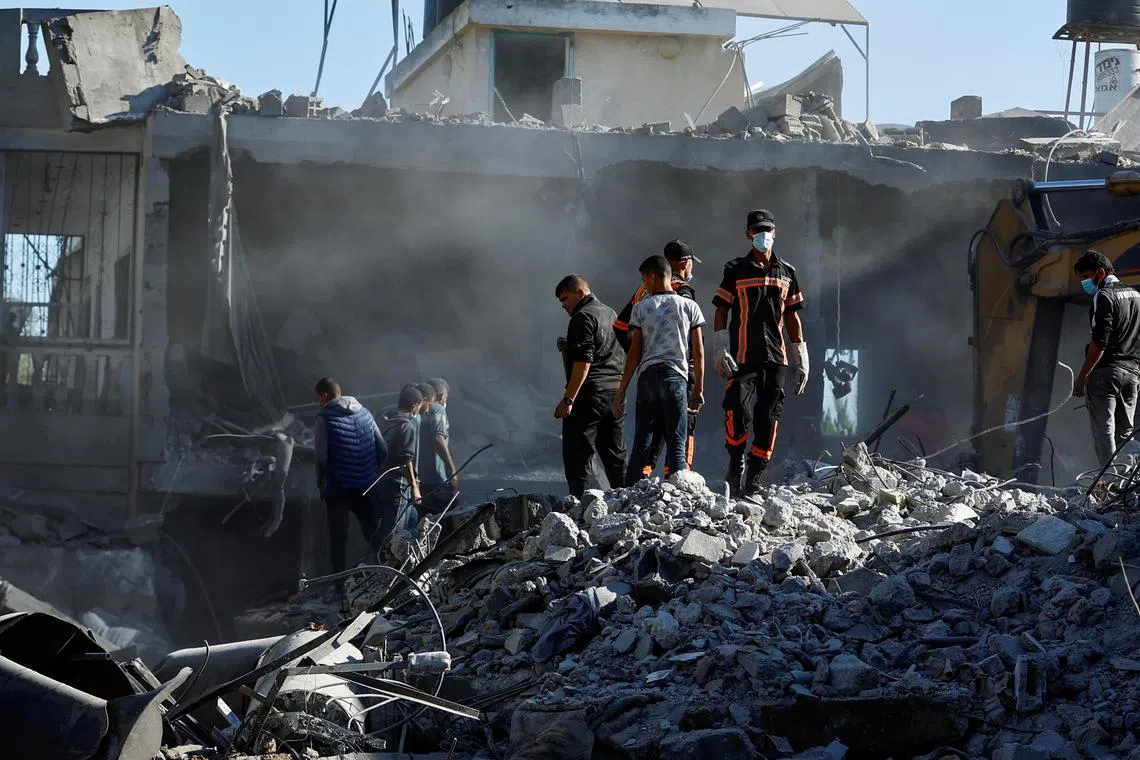 Palestinians searching for casualties under rubble in the aftermath of Israeli strikes, amid the ongoing conflict between Israel and Hamas, in Khan Younis, southern Gaza Strip, on Oct 13.