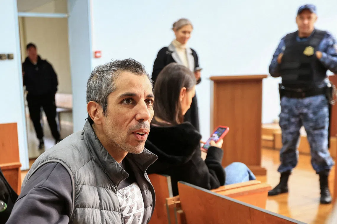 French cyclist Sofiane Sehili, who was found guilty of illegally crossing the Russian border while attempting to break the world record for the fastest cycle crossing of the Eurasian landmass and freed by a court that ordered him to pay a fine, sits in a courtroom in the far eastern settlement of Pogranichniy, Russia, October 23, 2025. REUTERS/Tatiana Meel