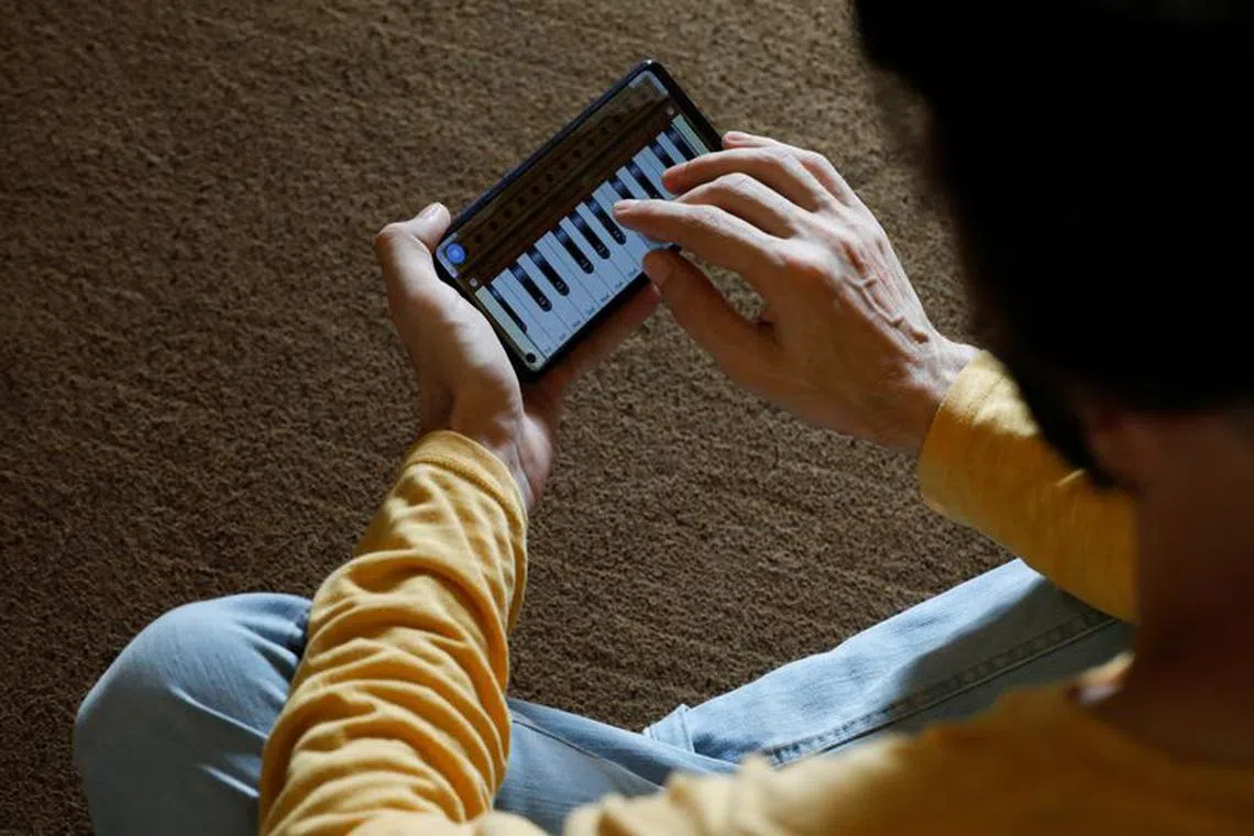 Saleh Zada, 32, a singer and songwriter, who was born in Badakhshan province and later moved to Kabul for his education, plays a music composition on his mobile harmonium app during an interview with Reuters, in Karachi, Pakistan November 4, 2023. REUTERS/Akhtar Soomro