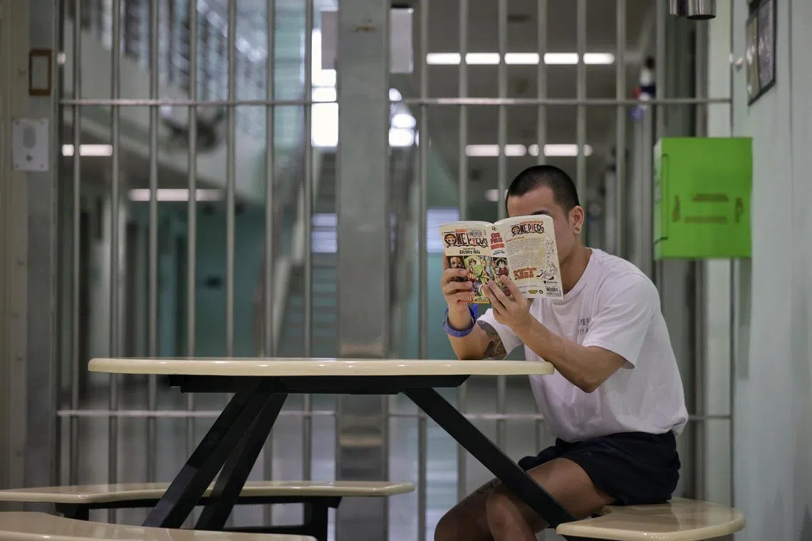 Profile of inmate Andy (not his real name), 26, reading a Japanese manga (comic series) book given to him by his parents in Institution A3 of Changi Prison Complex on Dec 20, 2024.