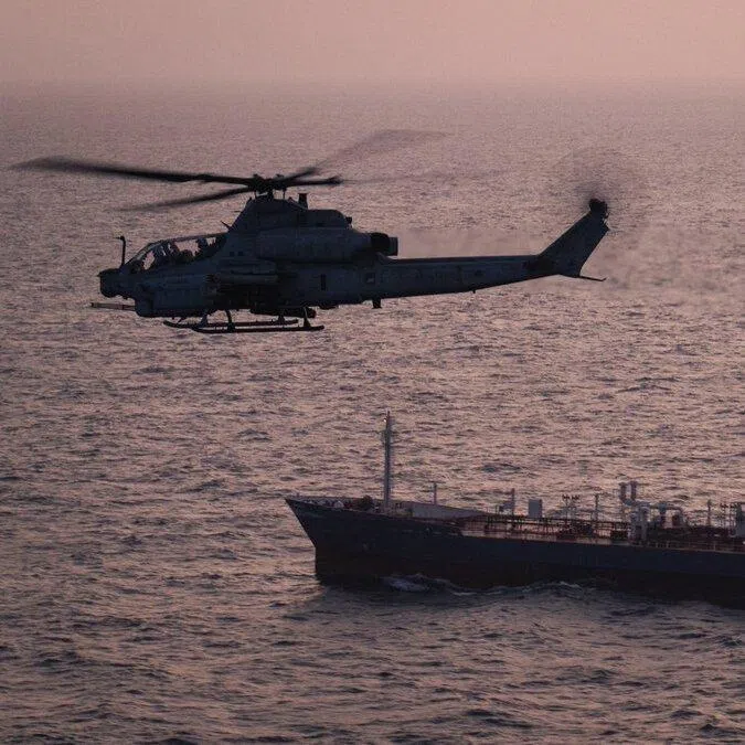 A US helicopter patrolling near a commercial vessel as American forces enforce the US' maritime blockade against Iran.