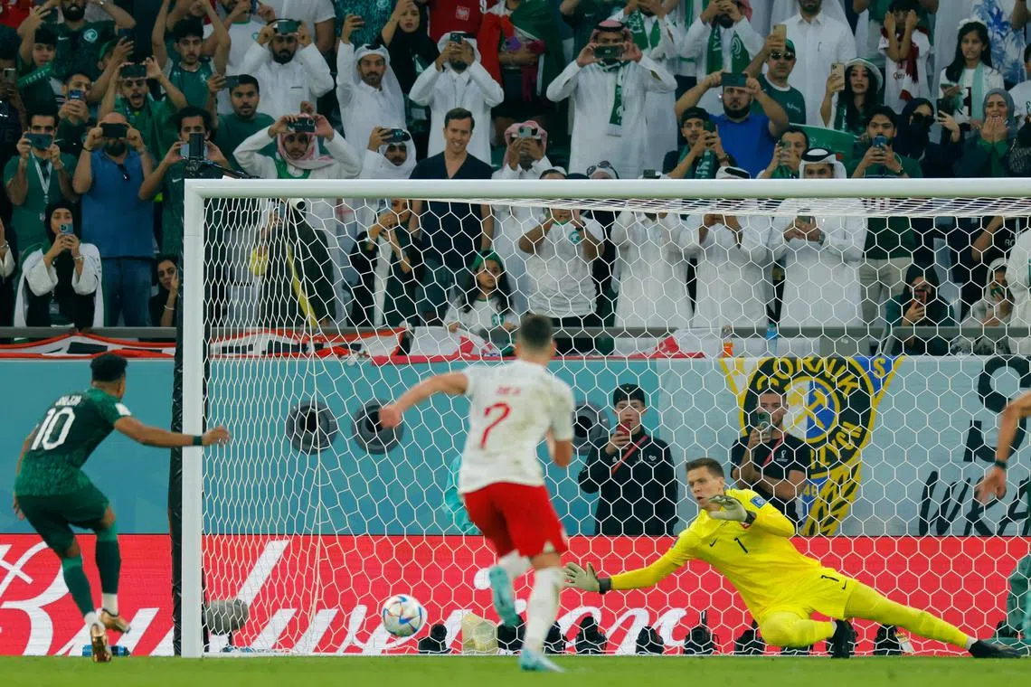 TOPSHOT - Poland's goalkeeper #01 Wojciech Szczesny stops a penalty by Saudi Arabia's midfielder #10 Salem Al-Dawsari during the Qatar 2022 World Cup Group C football match between Poland and Saudi Arabia at the Education City Stadium in Al-Rayyan, west of Doha on November 26, 2022. (Photo by Odd ANDERSEN / AFP)