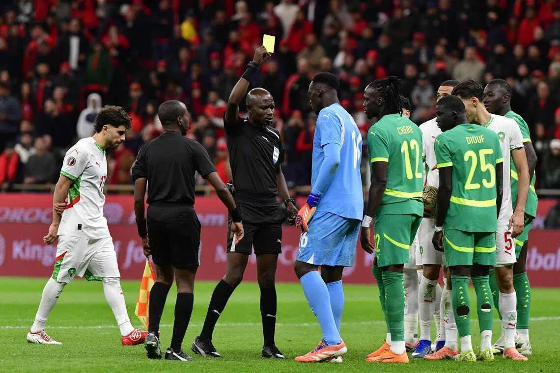 Referee Jean-Jacques Ngambo Ndala giving a yellow card to Senegal goalkeeper Edouard Mendy in the Africa Cup of Nations final on Jan 18.