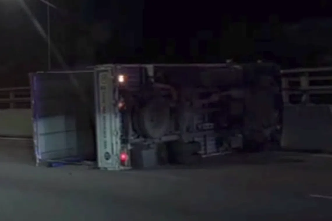 A lorry was seen overturned next to the road divider.