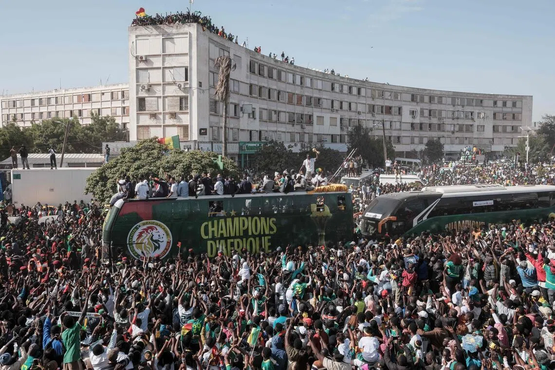 Senegal supporters cheering as the country's footballers ride on a bus during a trophy parade in the streets of Dakar on Jan 20, 2026 as they celebrate winning the Africa Cup of Nations that was hosted in Morocco.