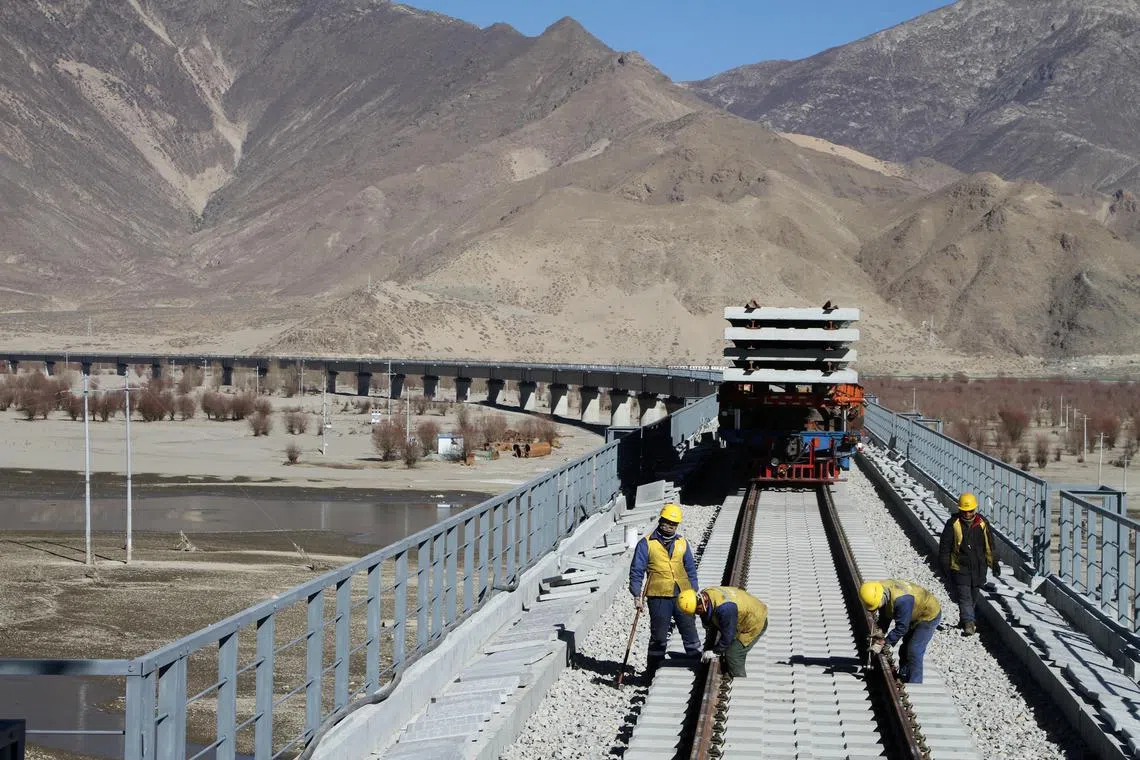 FILE PHOTO: Workers are seen on railway tracks at a bridge over Yarlung Tsangpo river as they work on the construction of the railroad linking Lhasa and Nyingchi, in Tibet Autonomous Region, China November 26, 2018. Picture taken November 26, 2018.    Zhao Lang/CNS via REUTERS/File Photo