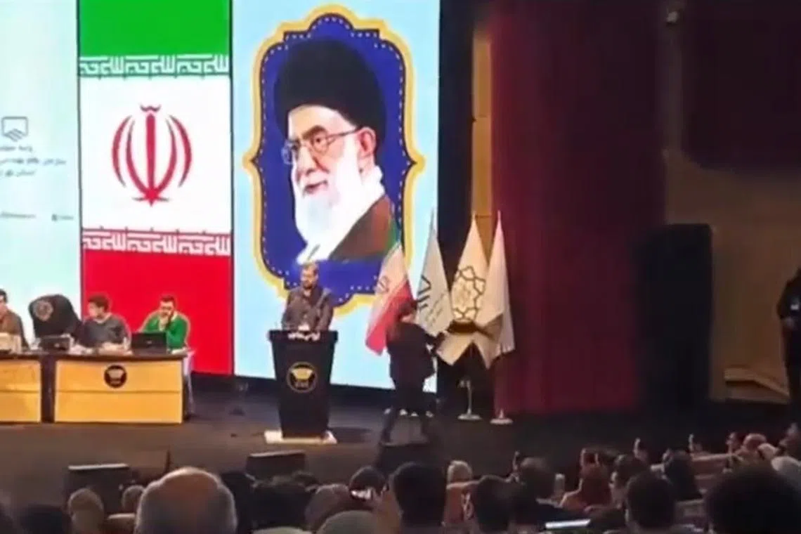 A screenshot from a video of the incident posted online shows audience members applauding as the woman pulls off her hijab and walks out.