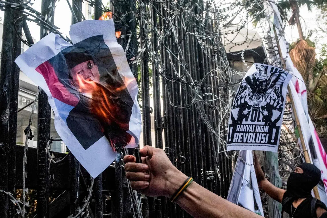 A demonstrator sets on fire a poster of Indonesia’s President Prabowo Subianto during a protest demanding police reform and the dissolution of the parliament, in Bandung, West Java on Sept 1, 2025. 