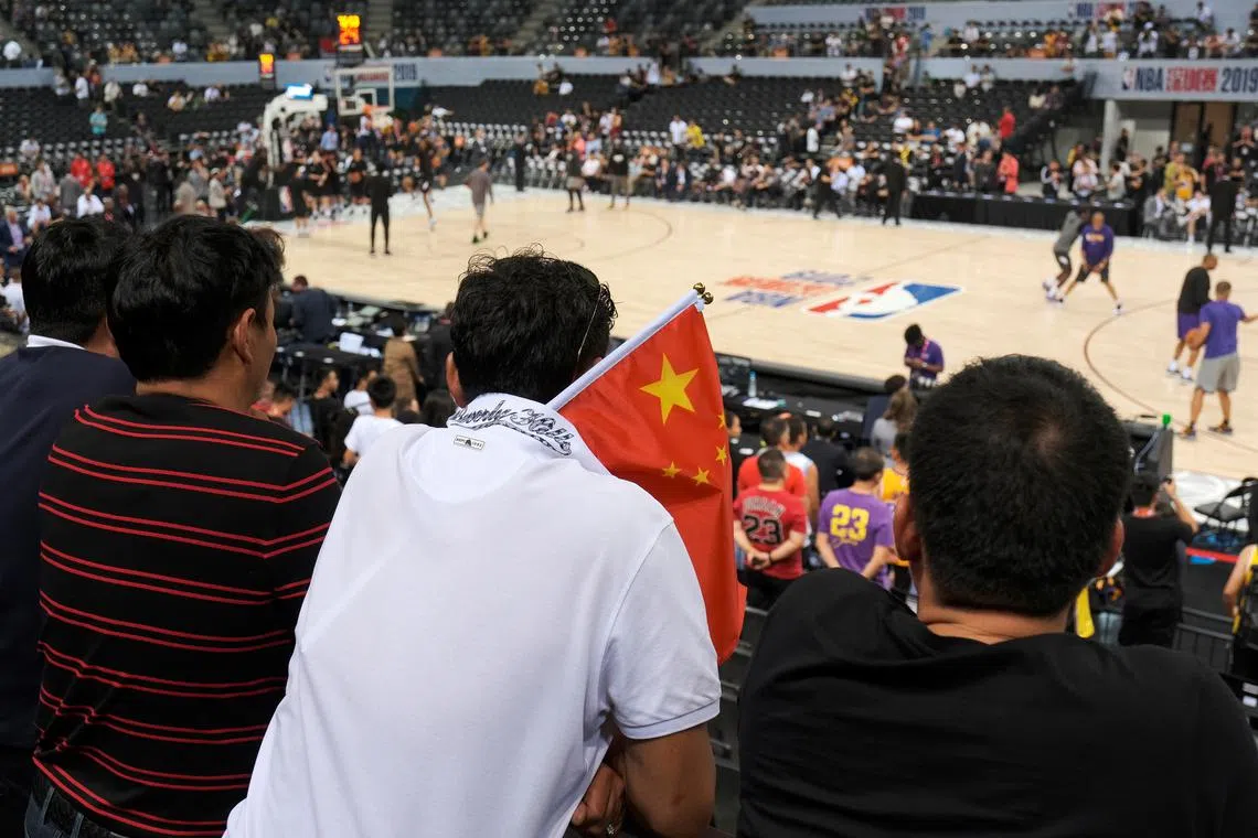 FILE PHOTO: Basketball - NBA China Games - Los Angeles Lakers v Brooklyn Nets - Shenzhen, China - October 12, 2019. A fan carries a Chinese national flag during the game. REUTERS/Tyrone Siu/File Photo