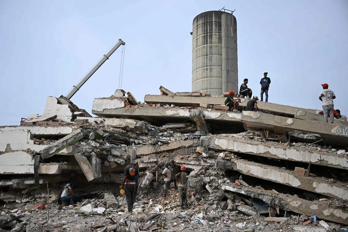 Workers remove debris from a collapsed building in Caraballeda, La Guaira state, Venezuela, on July 9, following the June 24 earthquakes.