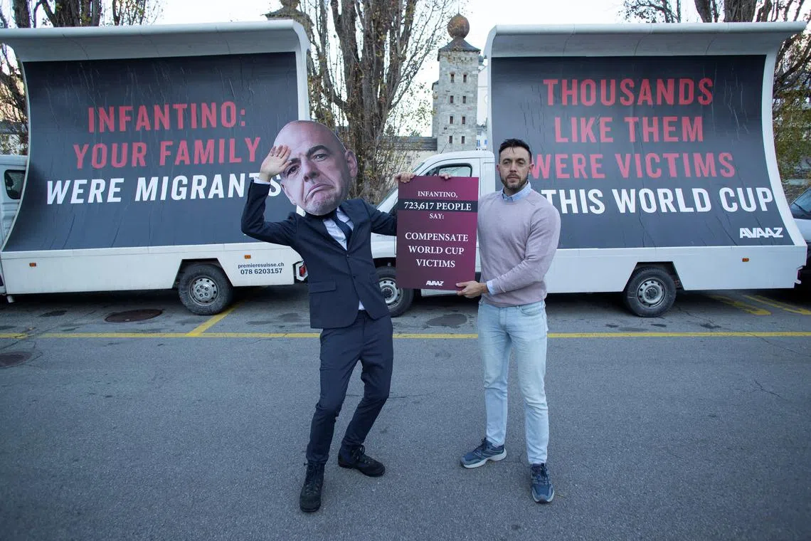 An activist wears a portrait of Fifa chief Gianni Infantino during a protest of social movement group Avaaz, to demand the world football body compensate migrant workers for alleged human rights abuses in Qatar.