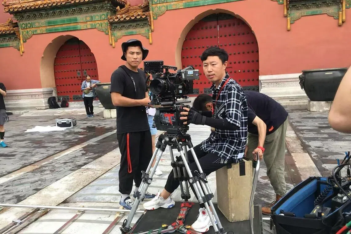 Beijing-based documentary film director Niu Jiangchao (seated) uses generative AI to turn research into draft scripts and to speed up planning for new films.
