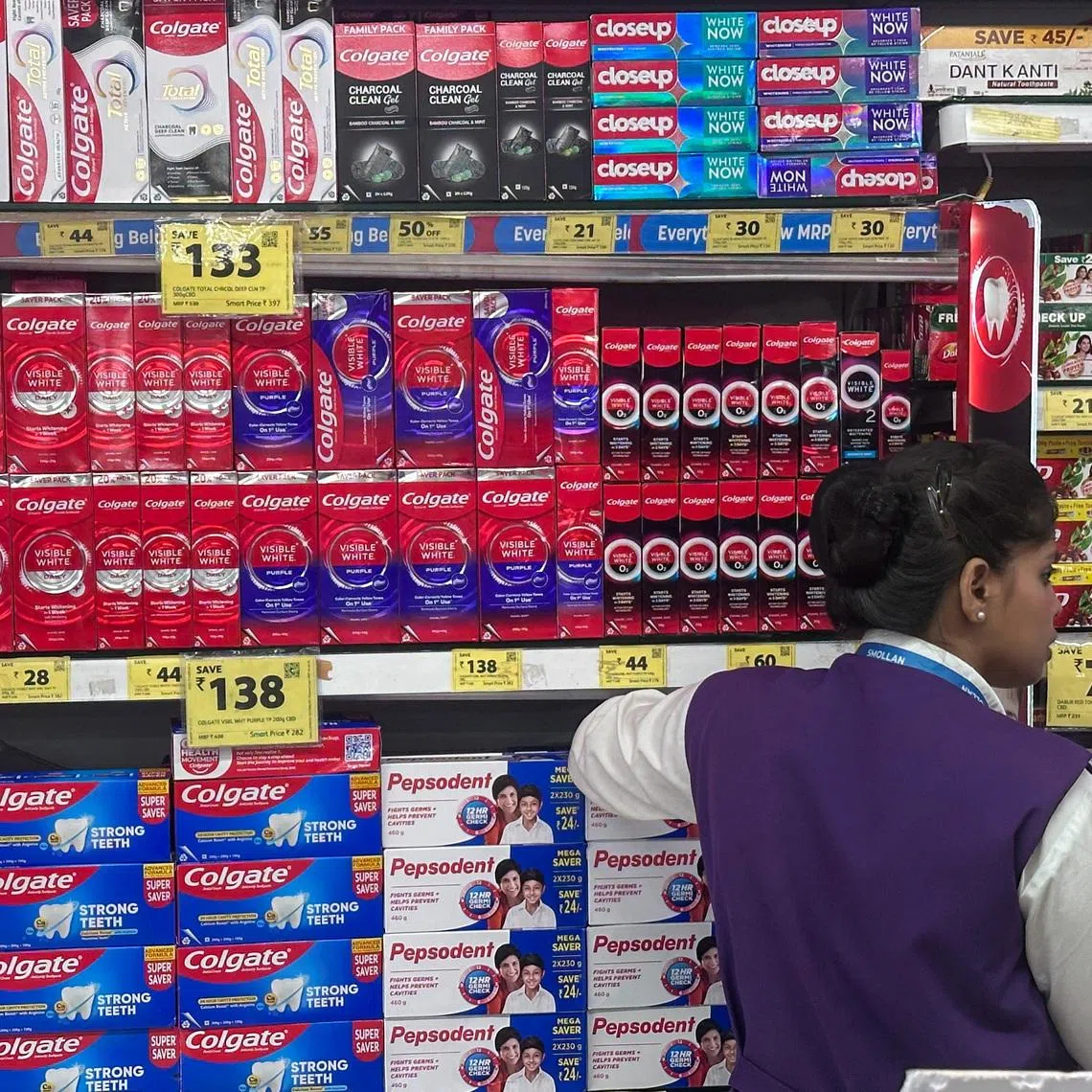 A woman stands next to toothpaste boxes at a supermarket in Mumbai, India, September 4, 2025. REUTERS/Francis Mascarenhas