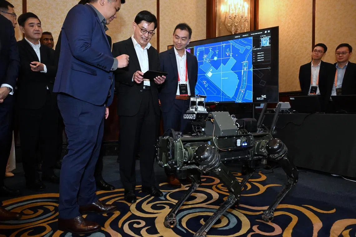 DPM Heng Swee Keat trying his hand at controlling the legged robot using DSTA?s robotics-enabled C3 at the Singapore Defence Technology Summit on March 19, 2025.