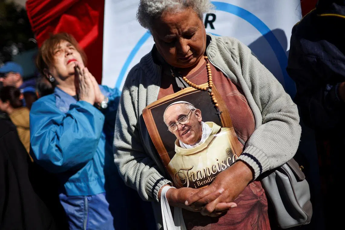 A woman holding a picture of Pope Francis outside the Buenos Aires Metropolitan Cathedral, following the death of the pontiff, in Buenos Aires, Argentina, on April 26, 2025. 